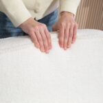 Modernus minkštas krėslas su bouclé audinio apmušalais ir kaučiukmedžio rėmu bei pagalvėle