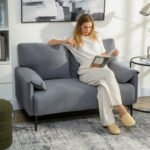 Kompaktiška dvivietė sofa su aksominiu apmušalu ir storomis pagalvėlėmis