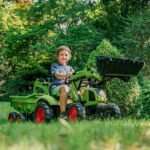 Žalias pedalinis traktorius CLAAS su kaušu, krautuvu ir priekaba