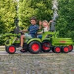 Žalias pedalinis traktorius CLAAS su kaušu, krautuvu ir priekaba