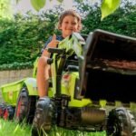 Žalias pedalinis traktorius CLAAS su kaušu, krautuvu ir priekaba