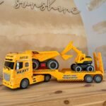 Didelis statybų transporteris su ekskavatoriumi, savivarčiu ir efektais